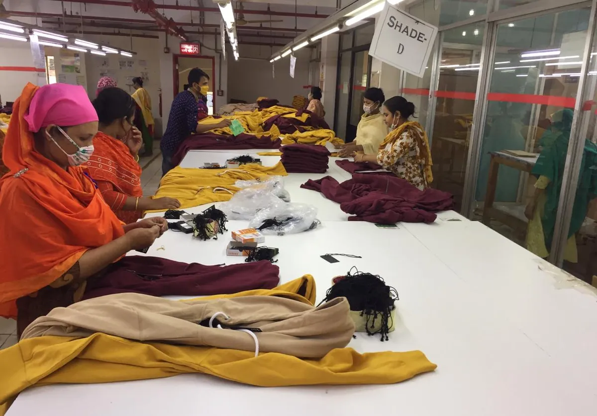 Finished orange garments at the inspection table