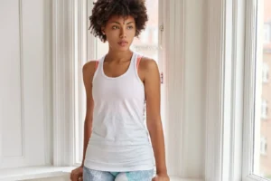 photo-thoughtful-dark-skinned-girl-wears-white-casual-t-shirt-stands-near-window-indoor-rainy-day-has-pensive-look-aside_273609-19070