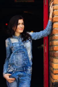 woman-stands-near-door-building-holds-her-hand-wall